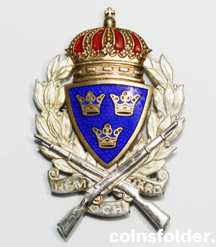 1938 Swedish Silver "Home and Hearth" Military Shooting Badge with a blue shield, three crowns, and crossed rifles.