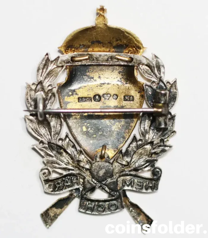 1938 Swedish Silver "Home and Hearth" Military Shooting Badge with a blue shield, three crowns, and crossed rifles.